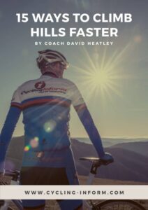 A cyclist in a blue kit stands with a bicycle on a hilltop, looking at distant mountains under a bright sun. Text reads: 15 Ways to Climb Hills Faster by Coach David Heatley and www.cycling-inform.com.